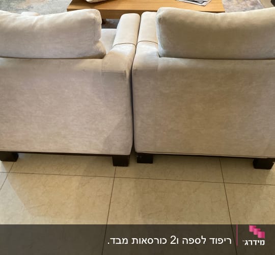 שתי ספות מרופדות בבד בהיר עם רגלי עץ כהות